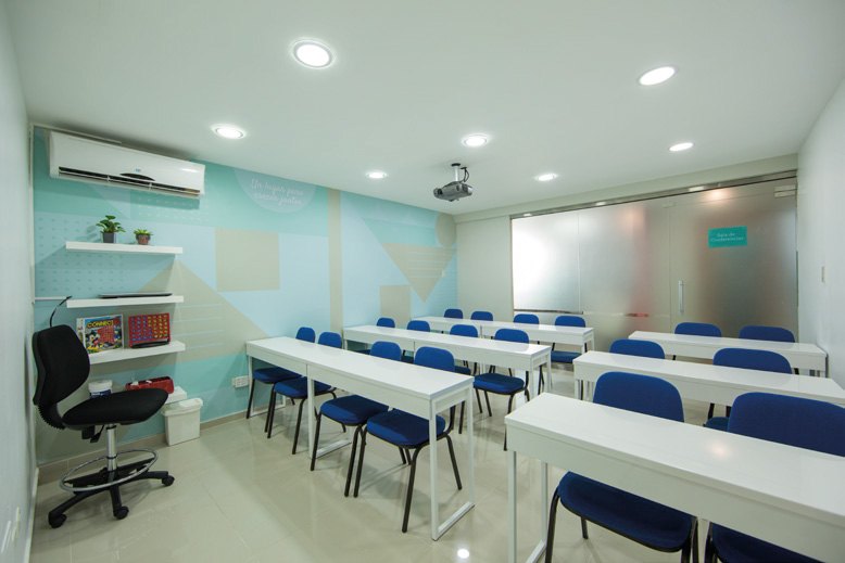 Aula con mesas blancas y sillas azules