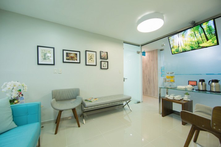 Sala de espera con sofá turquesa y cuadros en la pared
